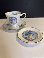 Front view of teacup, saucer and side plate showing Queen Mother portraits and gold rims