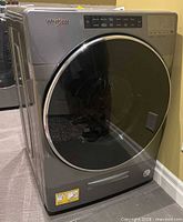 Front view of Whirlpool Chrome Shadow front-load washer with control panel and glass door