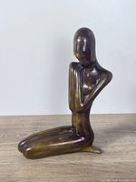 Front view of abstract ceramic kneeling woman figurine