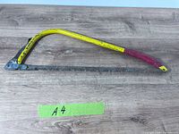 Full view of bow saw on wooden surface