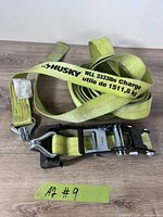 Overall view of Husky yellow tie-down strap coiled with ratchet
