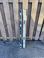 Full view of both 48-inch levels leaning against fence