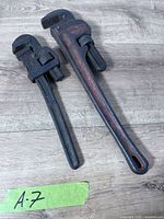Two adjustable pipe wrenches side by side for size comparison