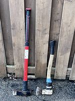 Full view of both axes leaning against fence