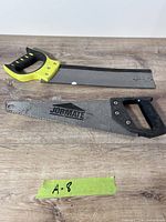 Two hand saws laid on wood surface