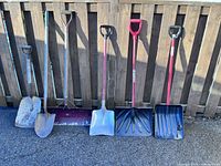 All six shovels leaning against fence
