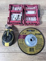 Overall view of DeWalt chalk line reel, DeWalt grinding disc and two red bit cases