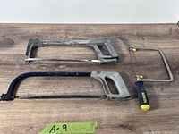 Two full-size hacksaws and one Irwin junior hacksaw displayed on wood surface