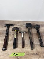 Five hammers laid out on wood surface