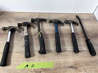 Overview of five hammers and pry bar on tabletop