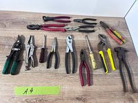 All items laid out on tabletop showing variety of pliers, snips, screwdrivers and trim tools