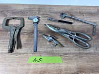 All six tools laid out on wooden surface with tag A-5