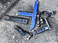 Assorted ball mounts, balls, pin on pavement