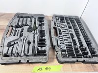Both halves of gray case showing sockets and tools