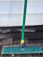 Close view of broom head, bristles, and handle connector