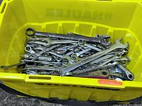 Top view of plastic tote filled with many combination wrenches