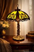 Full view of lamp lit on tabletop showing shade and base