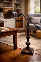 Full view of metal gooseneck desk lamp beside table
