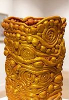 Close-up of vase surface showing spiral and bead relief