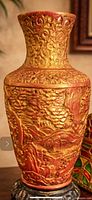 Front view of gold plaster/resin vase showing relief design and color