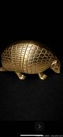 Full side view of brass armadillo figurine