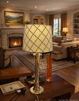 Full view of brass lamp on table with patterned shade