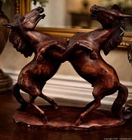 Front three-quarter view of signed twin rearing horse wood sculpture on base