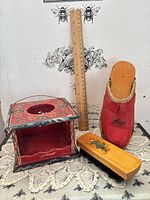 Overview of all three items: carriage foot warmer, clog, brush with ruler for scale