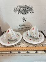 Two teacups resting on two saucers showing pattern and overall condition