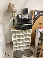 Overview of stacked audio components, lamp, speakers, shelf and bases