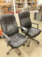 Front view of two black faux leather office chairs