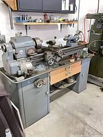 Front view of Delta engine lathe on cabinet base showing carriage, bed, and controls