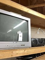 Polaroid CRT TV and Sony boombox on shelf