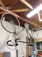 Full view of upside-down hanging Raleigh bicycle showing frame, wheels and components