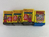 Front view of four representative sealed packs: Mario, Zelda, Princess Peach and Desert Storm designs