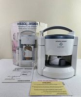 Jar opener on table with box, manual and card visible