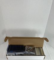 Open storage box showing sleeved card stack and loose cards