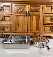 Roasting pan with rack beside covered fry pan