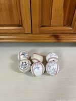 Front view of six baseballs displaying autographs and wear