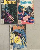 All three The Huntress comic books laid out front covers visible
