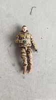 Front view of Duke Hauser action figure showing desert camo uniform, green gloves, brown boots