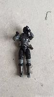 Front view of black and grey G.I. Joe figure lying on concrete
