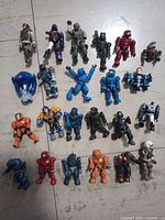 Full layout of all twenty figures and blue accessory on tiled floor