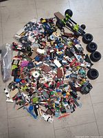 Bulk pile of assorted LEGO pieces spread on floor