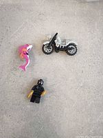 All three items—minifigure, motorcycle, shark—on flat surface