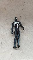 Front view of black suit Spider-Man figure showing white spider emblem