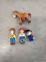 Front view of three Toy Story Lego minifigures and Bullseye horse