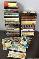 Two tall stacks of ancient history books on table