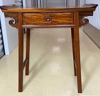 Front view of rosewood hall table showing drawer, fretwork, legs