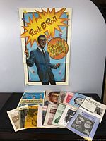 Group shot of poster behind 13 magazines/journals